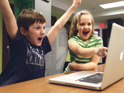 Zwei Kinder sitzen an einem Laptop