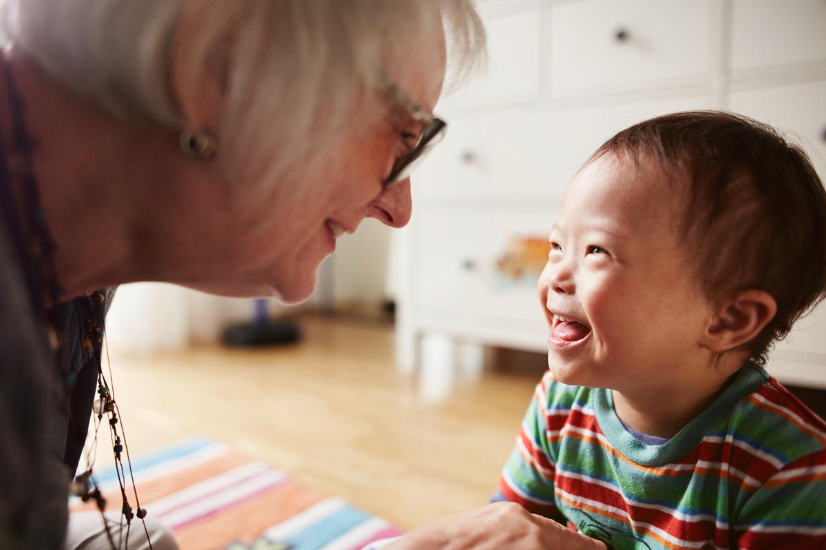Eine ältere Frau und ein Kleinkind lachen.