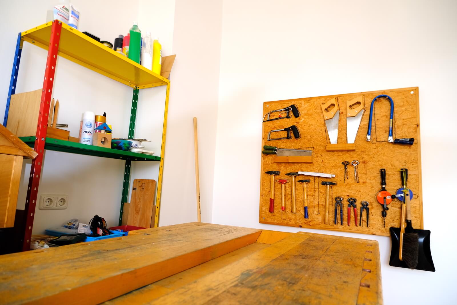 Werkbank aus Holz mit Werkzeug an einer Spanplatte an der Wand